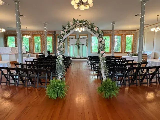 Ballroom ceremony setup with floral arch